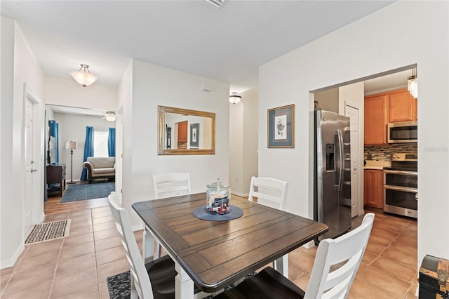 tiled dining space with ceiling fan