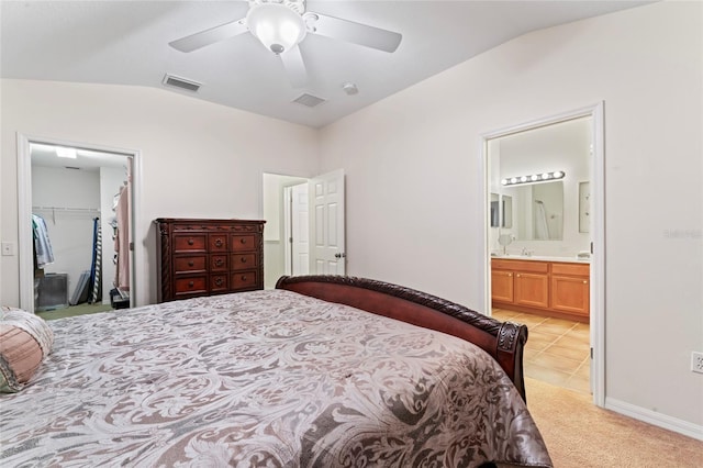 bedroom featuring ensuite bathroom, lofted ceiling, a walk in closet, ceiling fan, and a closet