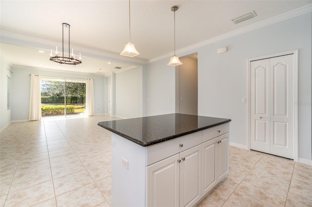 kitchen with light tile patterned flooring, crown molding, a center island, and white cabinets