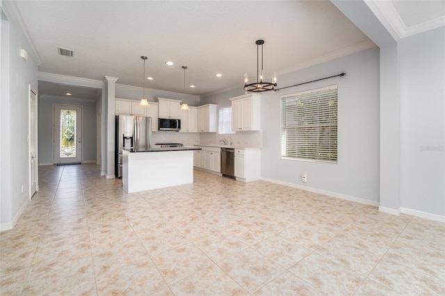 kitchen featuring pendant lighting, crown molding, stainless steel appliances, a center island, and white cabinets