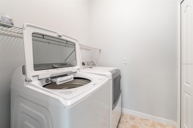 clothes washing area featuring independent washer and dryer and light tile patterned floors