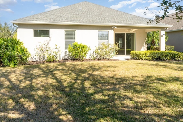 back of house with ceiling fan and a lawn