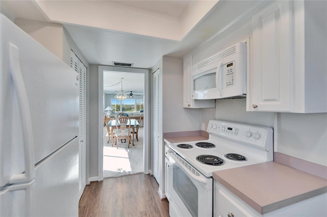 kitchen featuring white cabinetry, dark wood-type flooring, a chandelier, and white appliances