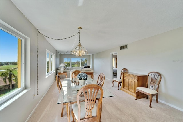 carpeted dining area with a notable chandelier