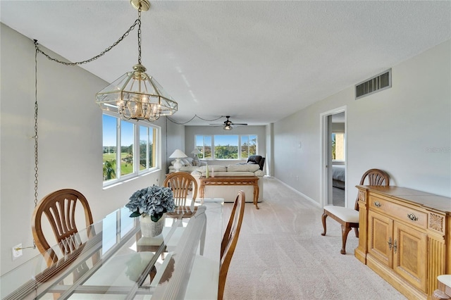 carpeted dining area featuring an inviting chandelier and a textured ceiling