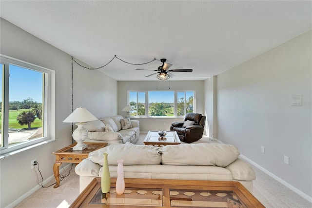 living room with carpet flooring, a textured ceiling, and ceiling fan