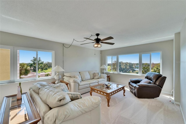 carpeted living room with ceiling fan and a textured ceiling