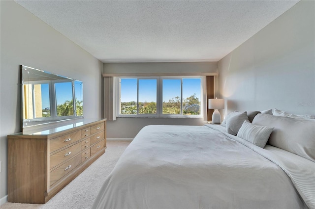 bedroom with light colored carpet and a textured ceiling