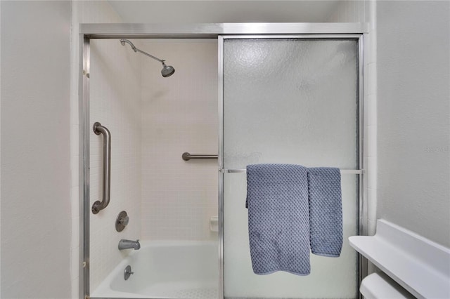 bathroom with shower / bath combination with glass door