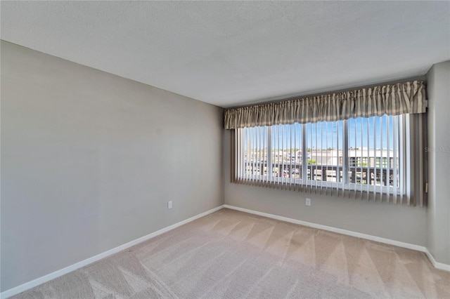 carpeted empty room with a textured ceiling