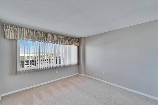 carpeted spare room featuring a textured ceiling