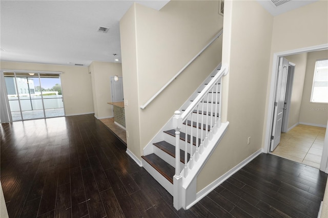 staircase with wood-type flooring and a wealth of natural light