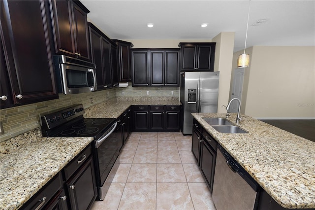 kitchen featuring sink, stainless steel appliances, tasteful backsplash, light stone counters, and decorative light fixtures