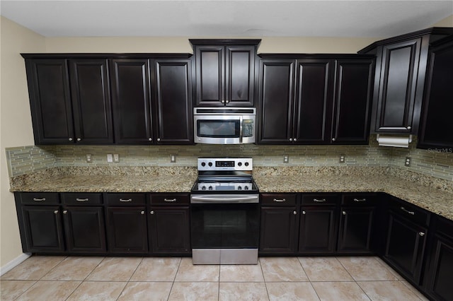 kitchen with light stone counters, light tile patterned floors, decorative backsplash, and stainless steel appliances