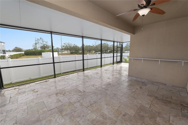 unfurnished sunroom featuring ceiling fan