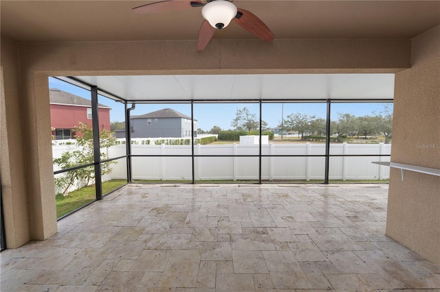 unfurnished sunroom with plenty of natural light and ceiling fan