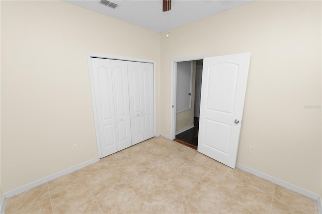 unfurnished bedroom featuring ceiling fan and a closet