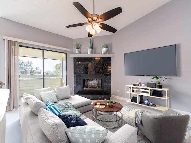 living room with ceiling fan and a high end fireplace