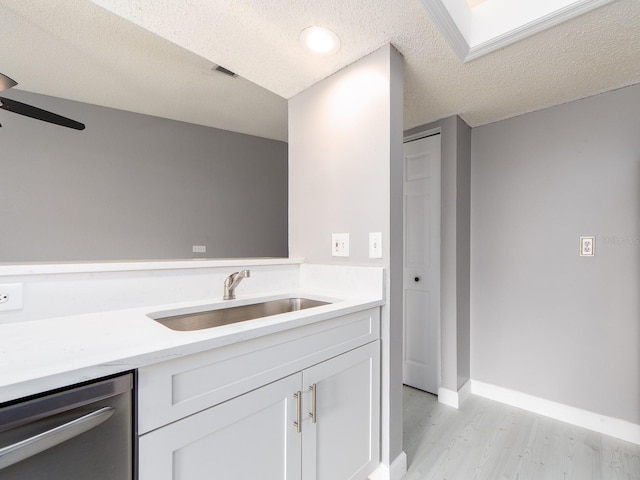 bathroom featuring ceiling fan, sink, hardwood / wood-style floors, and a textured ceiling