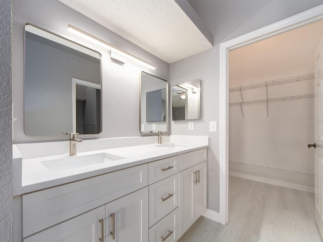 bathroom with vanity, hardwood / wood-style floors, and a textured ceiling