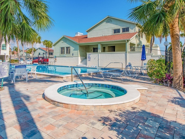 view of swimming pool with a hot tub and a patio