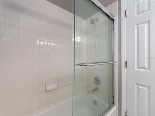 bathroom featuring bath / shower combo with glass door