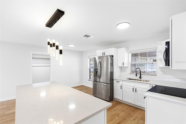 kitchen featuring white cabinetry, sink, hanging light fixtures, and stainless steel refrigerator with ice dispenser