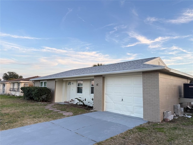 ranch-style home featuring a garage and a front lawn