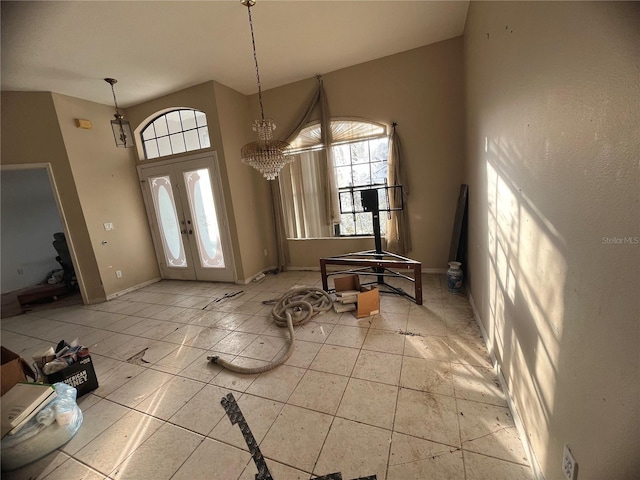 entryway with an inviting chandelier, french doors, and a high ceiling