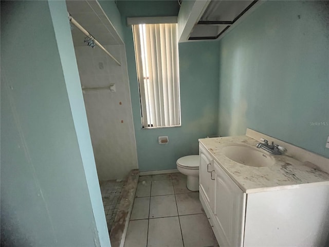 bathroom featuring walk in shower, vanity, toilet, and tile patterned flooring