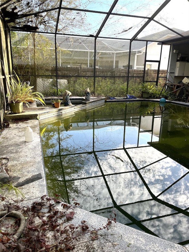 view of swimming pool featuring a lanai