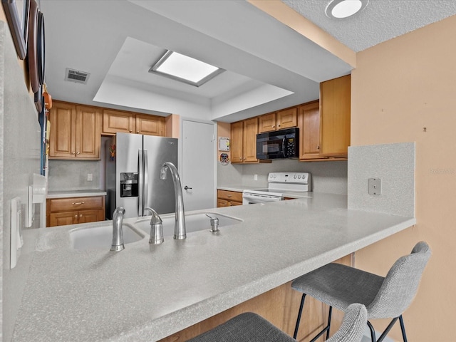 134 Mariner Dr Unit 134, Tarpon Springs, FL 34689 - kitchen with white electric range, stainless steel fridge, kitchen peninsula, and a kitchen bar