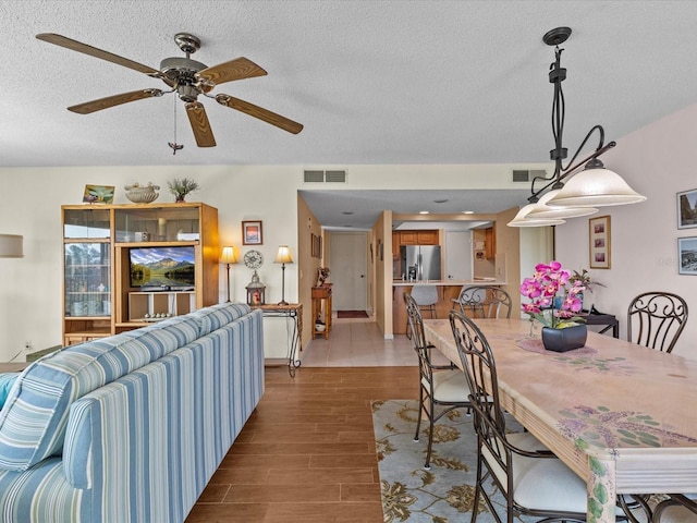 134 Mariner Dr Unit 134, Tarpon Springs, FL 34689 - dining area featuring ceiling fan, light hardwood / wood-style flooring, and a textured ceiling