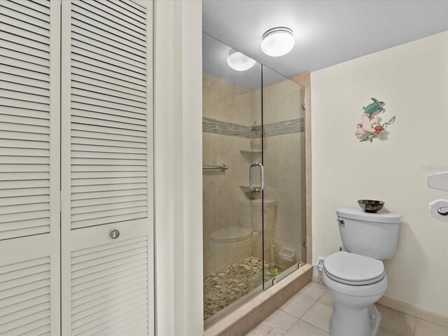 134 Mariner Dr Unit 134, Tarpon Springs, FL 34689 - bathroom with a shower with shower door, tile patterned floors, and toilet