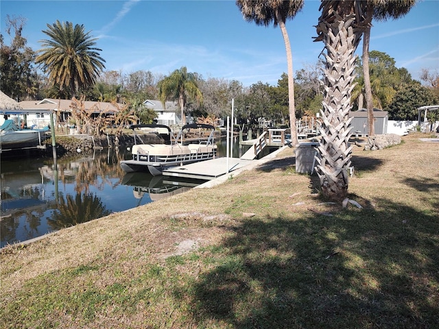 dock area featuring a water view and a lawn