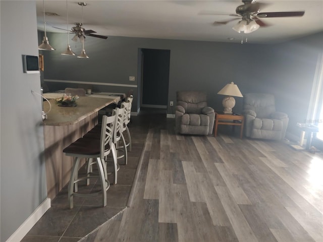 living room with dark hardwood / wood-style flooring and ceiling fan