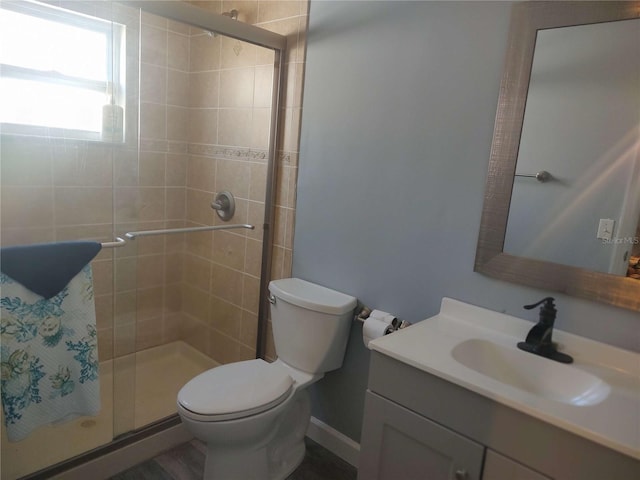 bathroom featuring an enclosed shower, vanity, and toilet