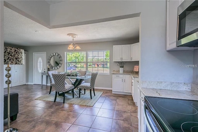 tiled dining room featuring a textured ceiling