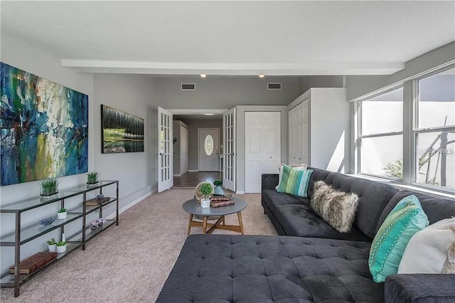 living room with beam ceiling and light colored carpet