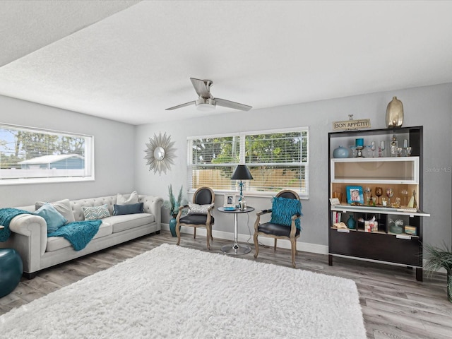 living room featuring hardwood / wood-style flooring, a wealth of natural light, and ceiling fan