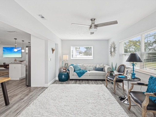 living room with ceiling fan and light wood-type flooring