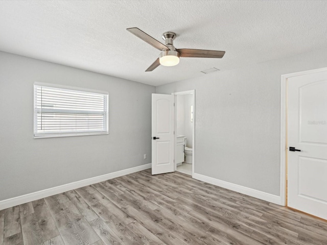 unfurnished bedroom with ensuite bathroom, ceiling fan, a textured ceiling, and light hardwood / wood-style floors