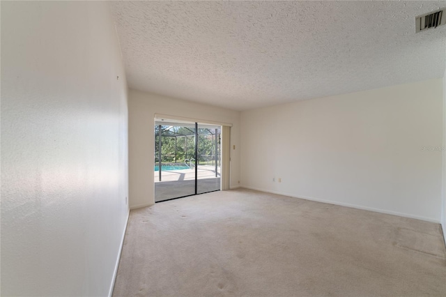 carpeted empty room with a textured ceiling