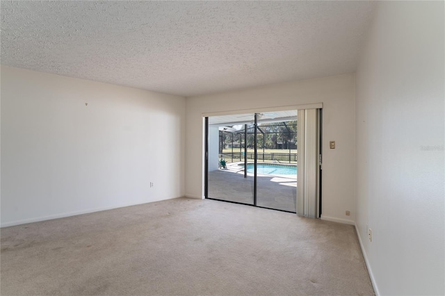 unfurnished room with light colored carpet and a textured ceiling