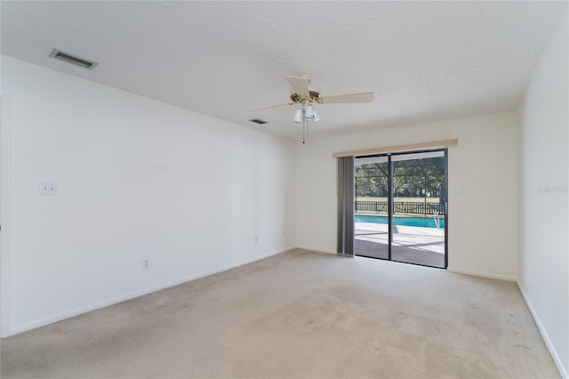 carpeted spare room with ceiling fan and a textured ceiling