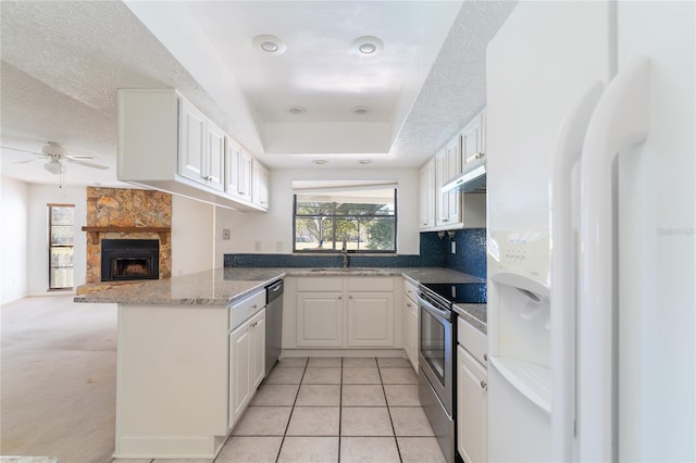 kitchen with sink, white cabinetry, appliances with stainless steel finishes, kitchen peninsula, and a healthy amount of sunlight