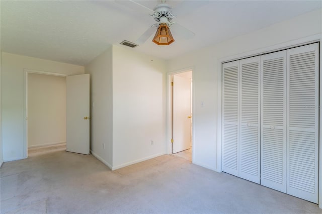 unfurnished bedroom featuring light colored carpet, a closet, and ceiling fan