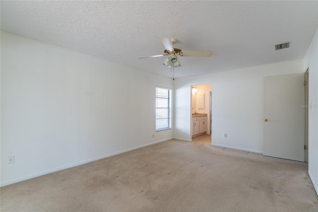 carpeted spare room with ceiling fan and a textured ceiling