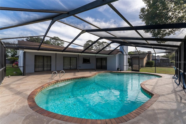 view of pool with a patio area and glass enclosure