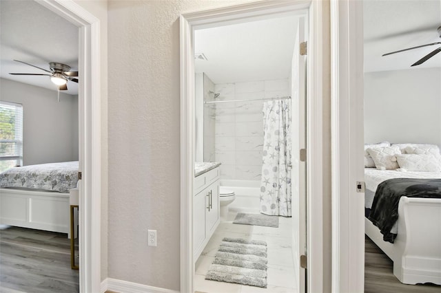 full bathroom featuring ceiling fan, hardwood / wood-style floors, vanity, toilet, and shower / bath combo with shower curtain